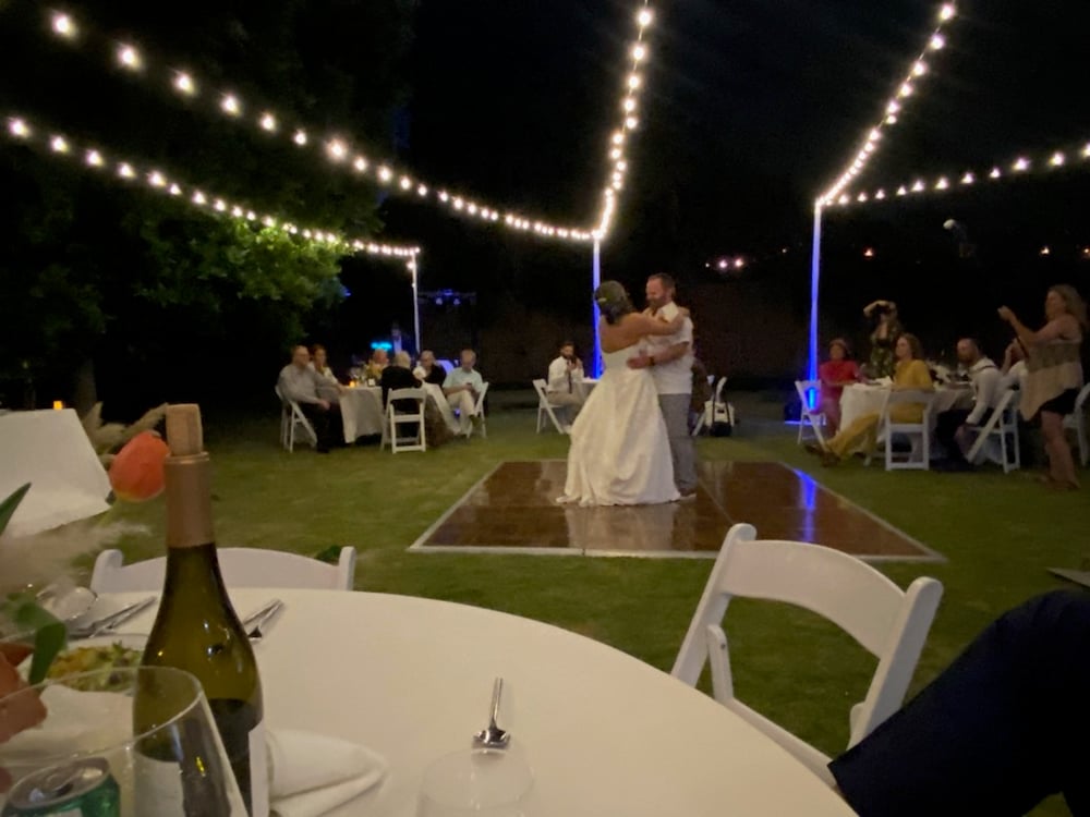 Wedding couple dancing under market lights